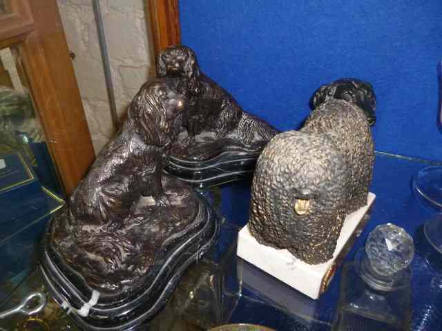 Appraisal: A PAIR OF BRONZES OF SEATED SPANIELS on shaped marble