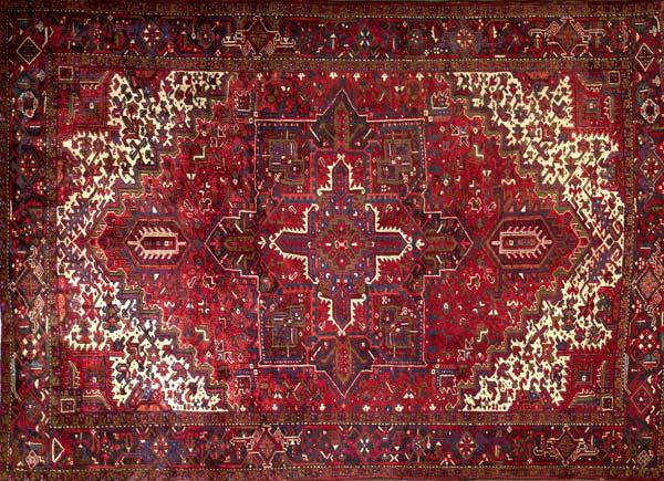 Appraisal: PERSIAN HERIZ Room-size rug with a geometric medallion in ruby