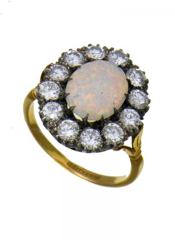 Appraisal: AN OPAL AND DIAMOND CLUSTER RING the oval opal cabochon