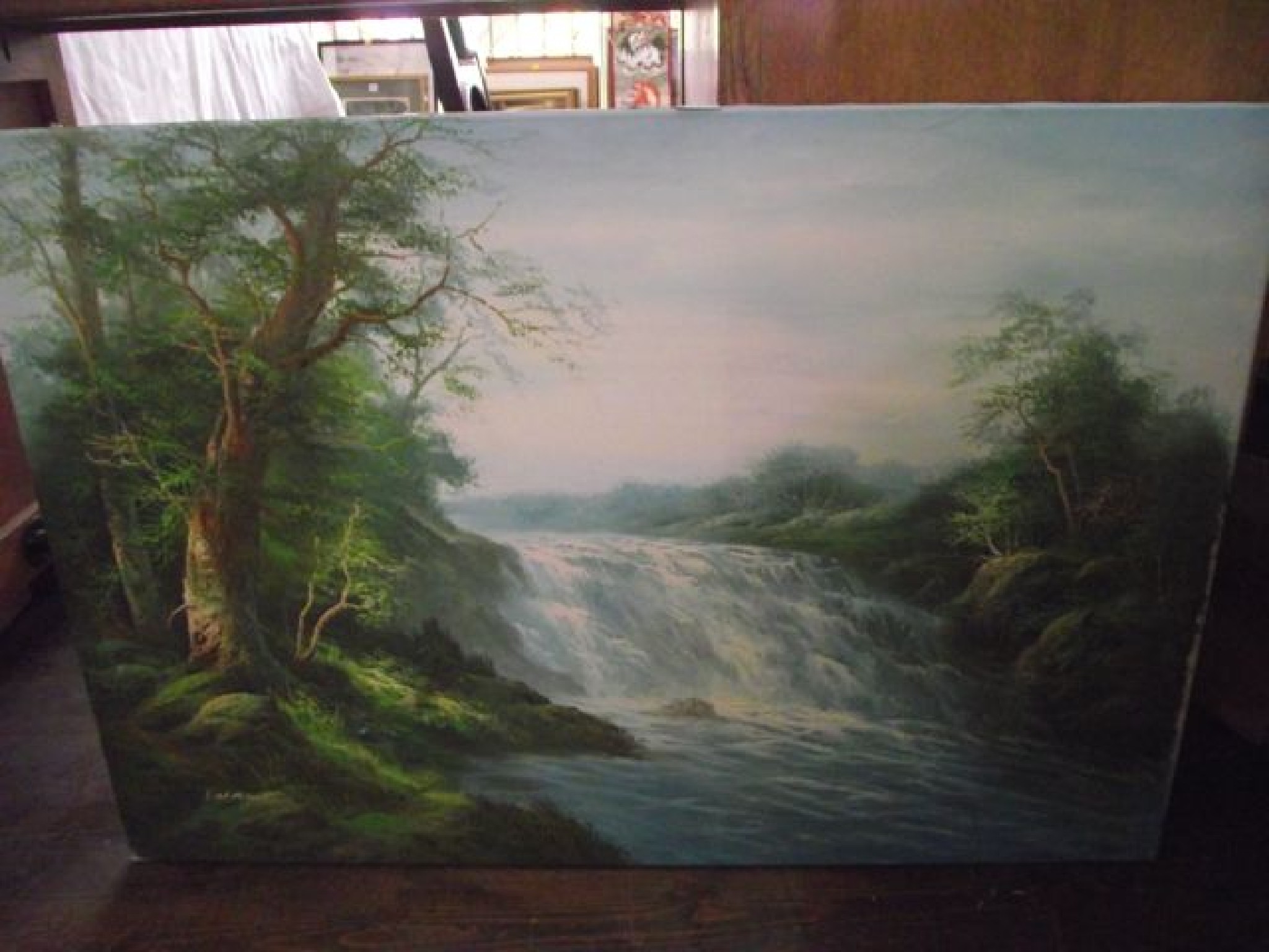 Appraisal: An oil painting on canvas of a waterfall indistinctly signed