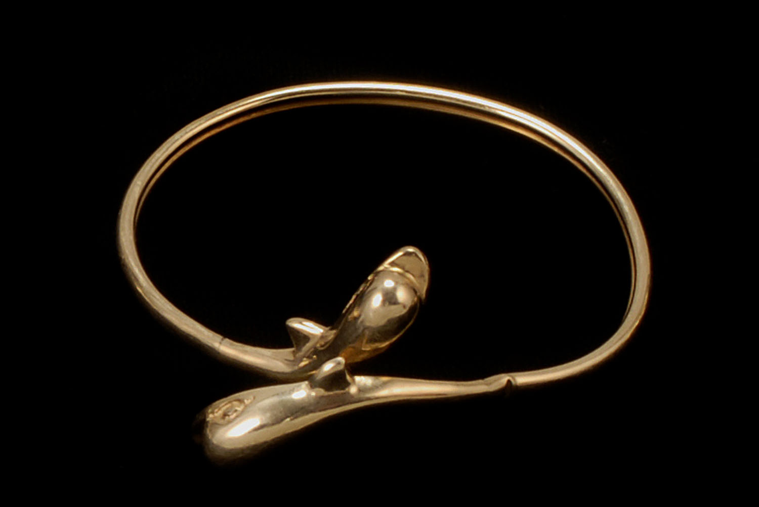 Appraisal: KT YELLOW GOLD FLEXIBLE BANGLE BRACELET With porpoise-form ends Diameter