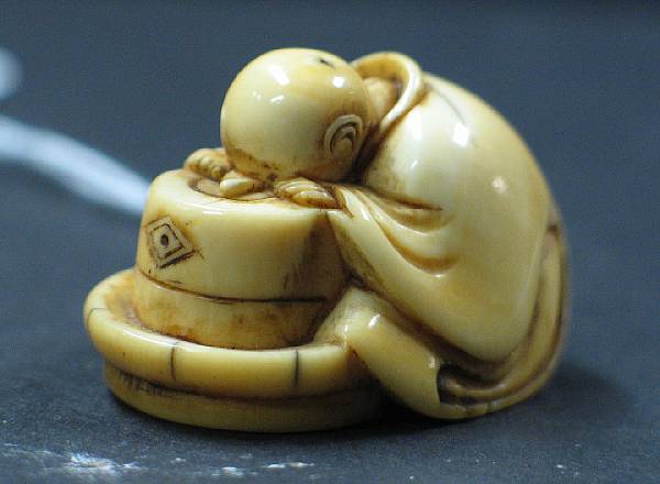 Appraisal: An ivory netsuke of a man asleep at a brazier