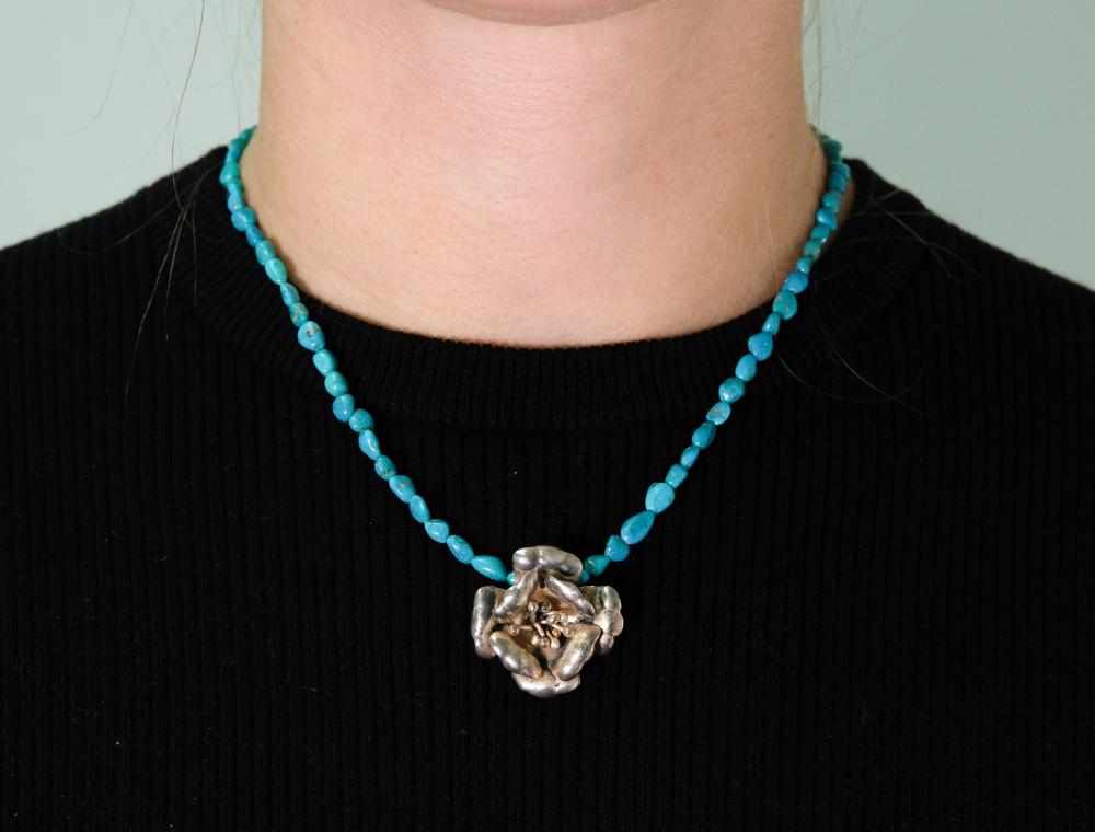 Appraisal: Sterling silver flower pendant hung on a turquoise beaded necklace