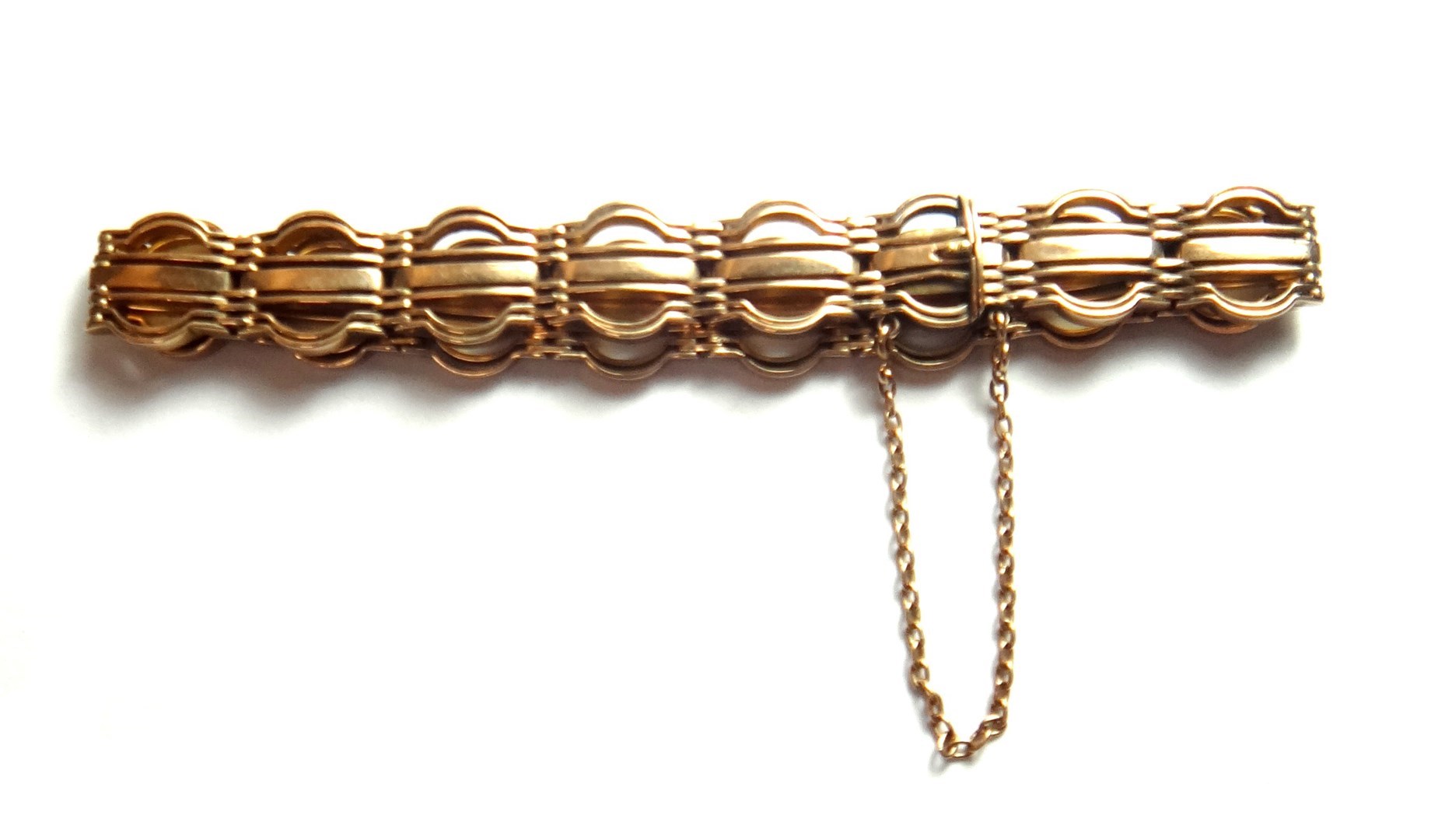 Appraisal: A gold bar and curved bar link gate bracelet on