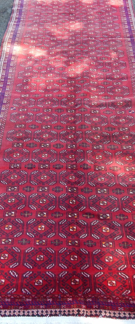 Appraisal: A Blooch Iranian carpet upon red ground with blue border