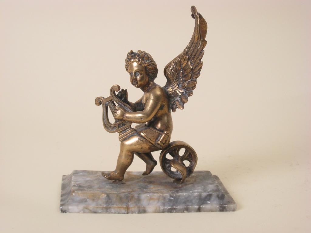 Appraisal: A brass figure of a winged Cherub in high