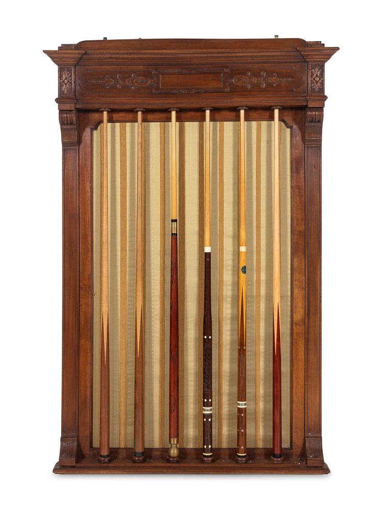 Appraisal: A Carved Walnut Billiards Cue Rack with a Set of