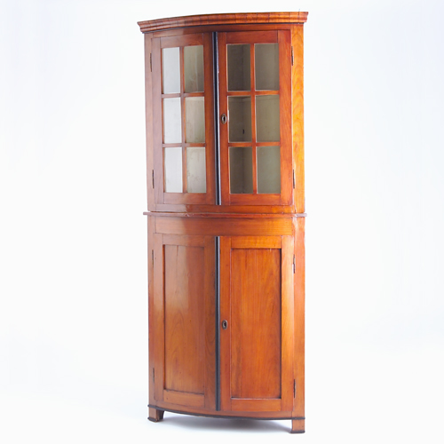 Appraisal: Biedermeier-style bowfront corner cupboard in two-over-two configuration the top with