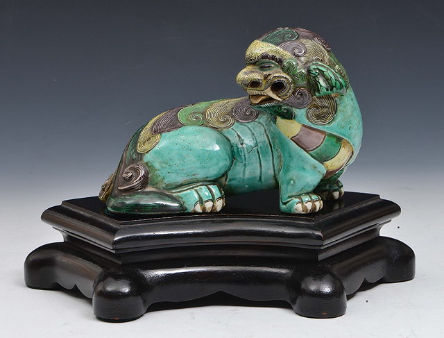 Appraisal: A CHINESE THREE COLOURED GLAZED BISCUIT PORCELAIN FIGURE OF A