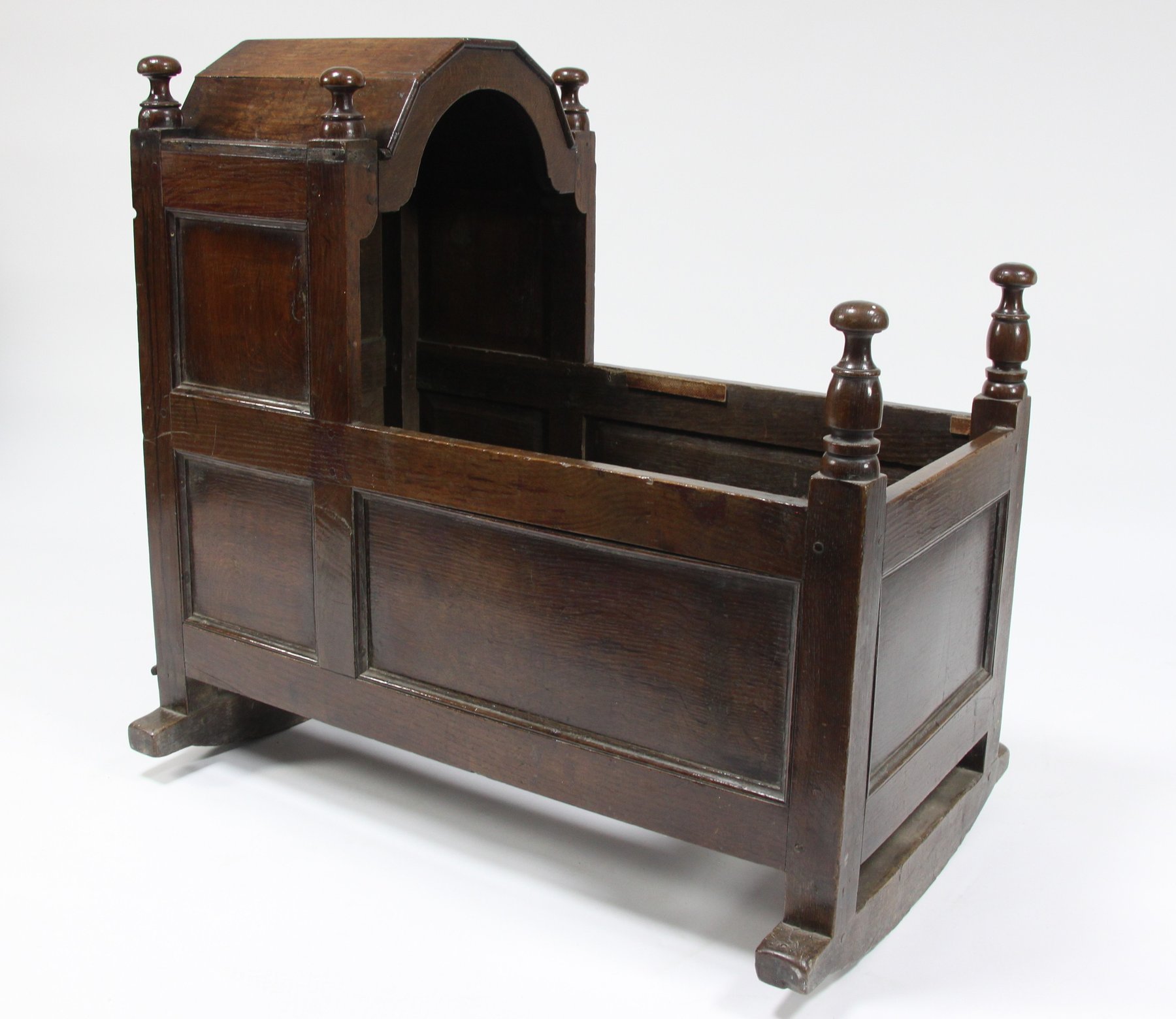 Appraisal: An early th Century oak panelled cradle with domed hood