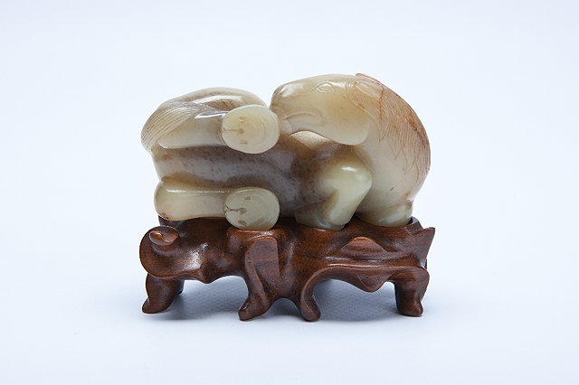 Appraisal: A CHINESE JADE GREYISH GREEN AND BROWN STRIATED RECLINING HORSE