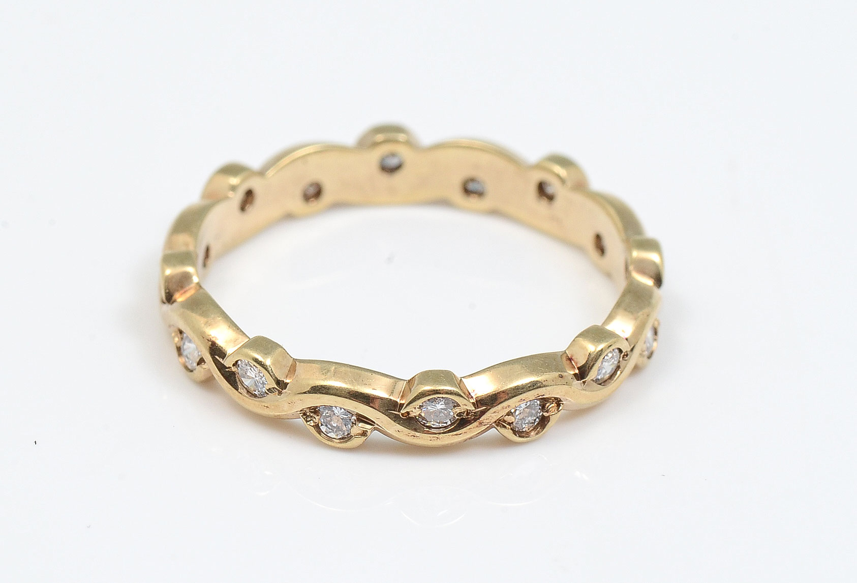 Appraisal: K DIAMOND BAND K yellow gold band is set around