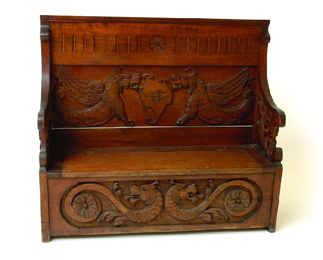 Appraisal: AN AUSTRALIAN CARVED BLACKWOOD SETTLE The panelled back and sides