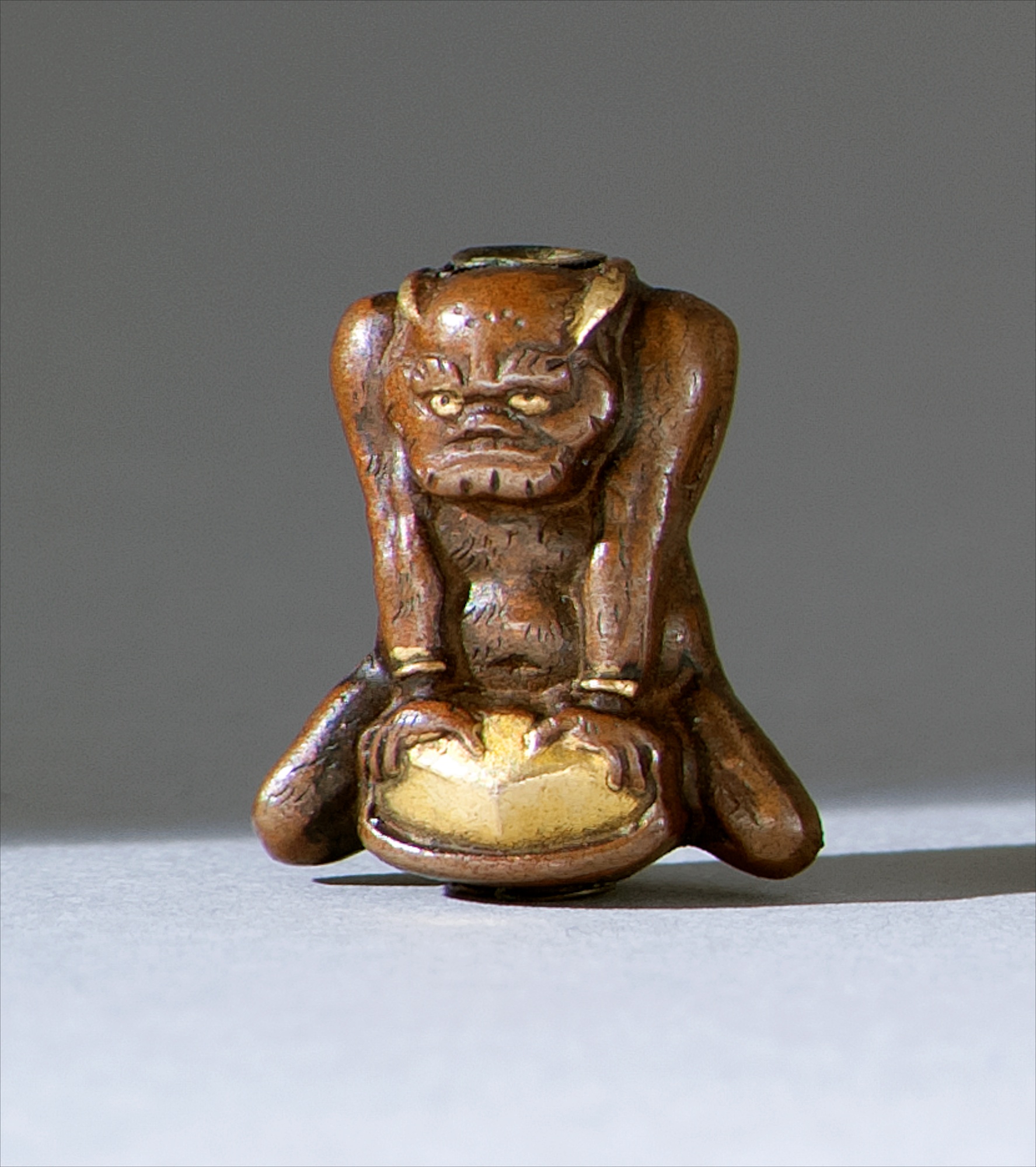 Appraisal: COPPER AND BRASS OJIME th CenturyDepicting an oni resting on