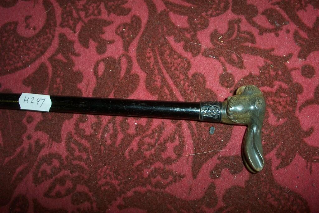 Appraisal: An ebony walking cane with silver mount and carved horn