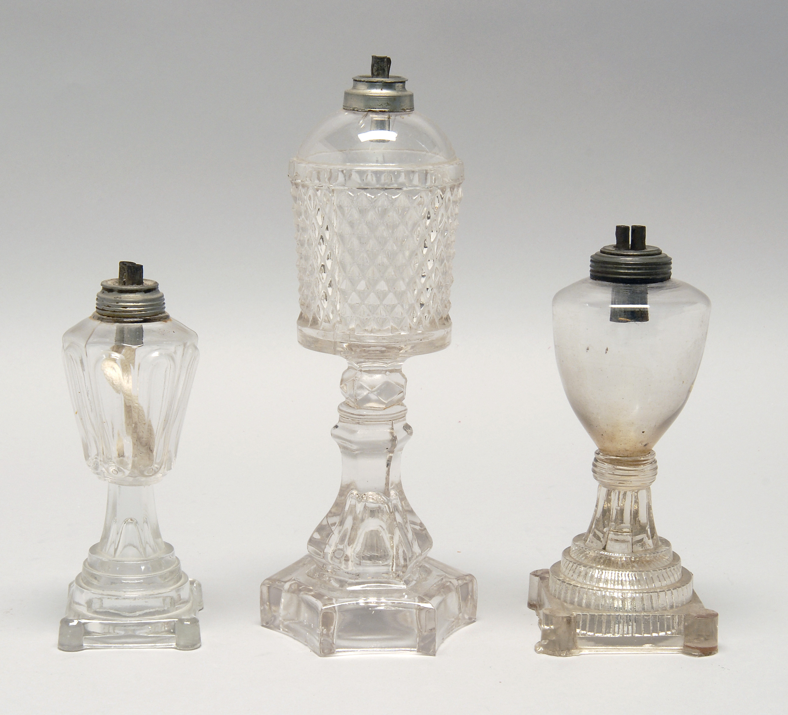 Appraisal: THREE TH CENTURY CLEAR GLASS WHALE OIL LAMPS Two are