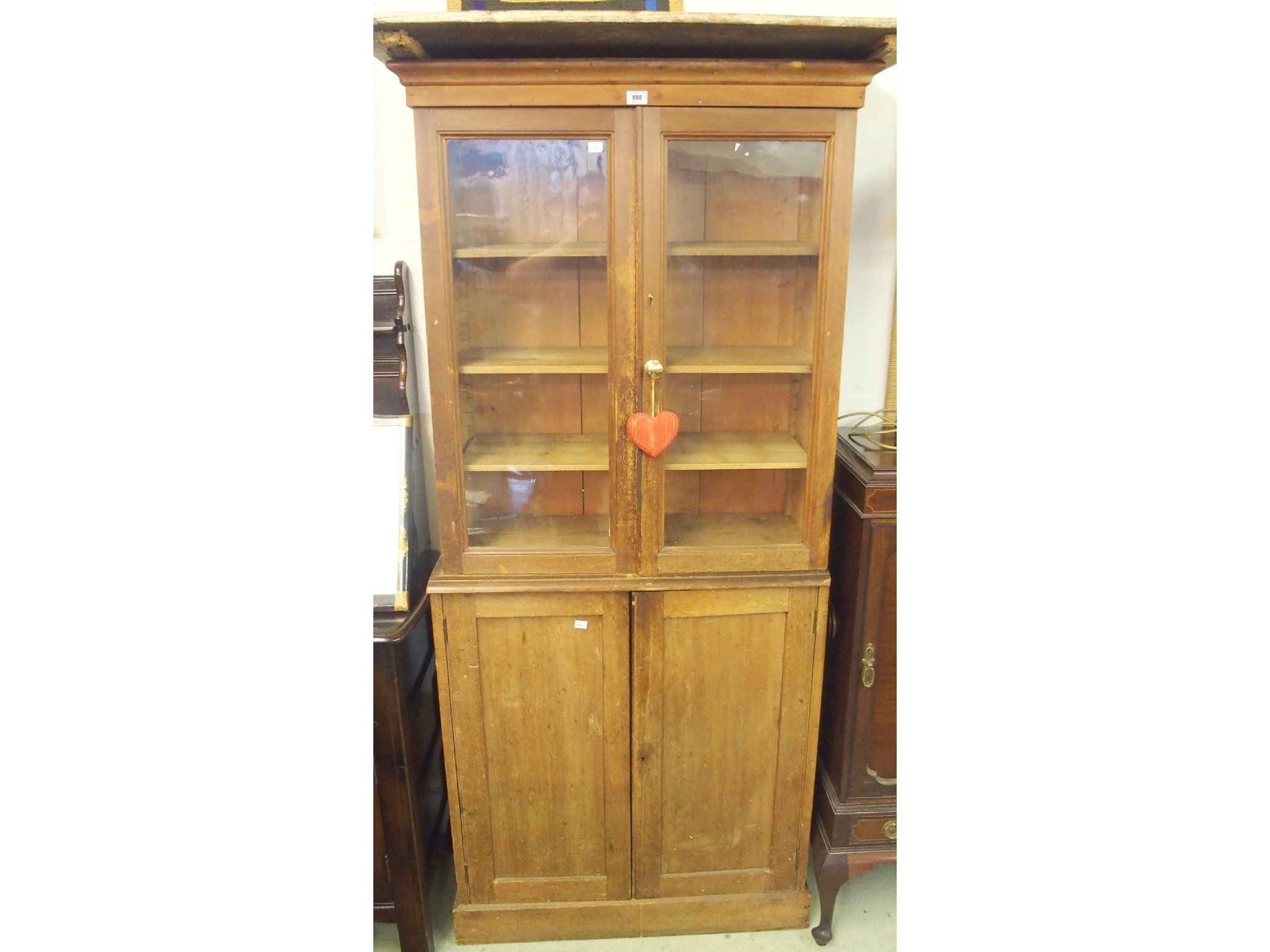 Appraisal: A glazed pine bookcase above a pair of doors x