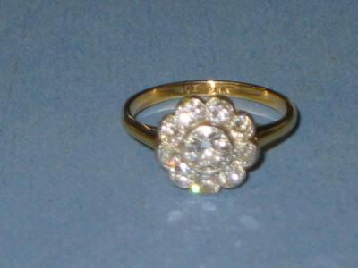 Appraisal: A DIAMOND CLUSTER RING modelled as a flowerhead with central