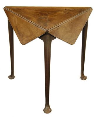 Appraisal: A George II mahogany triangular drop-leaf table the top constructed