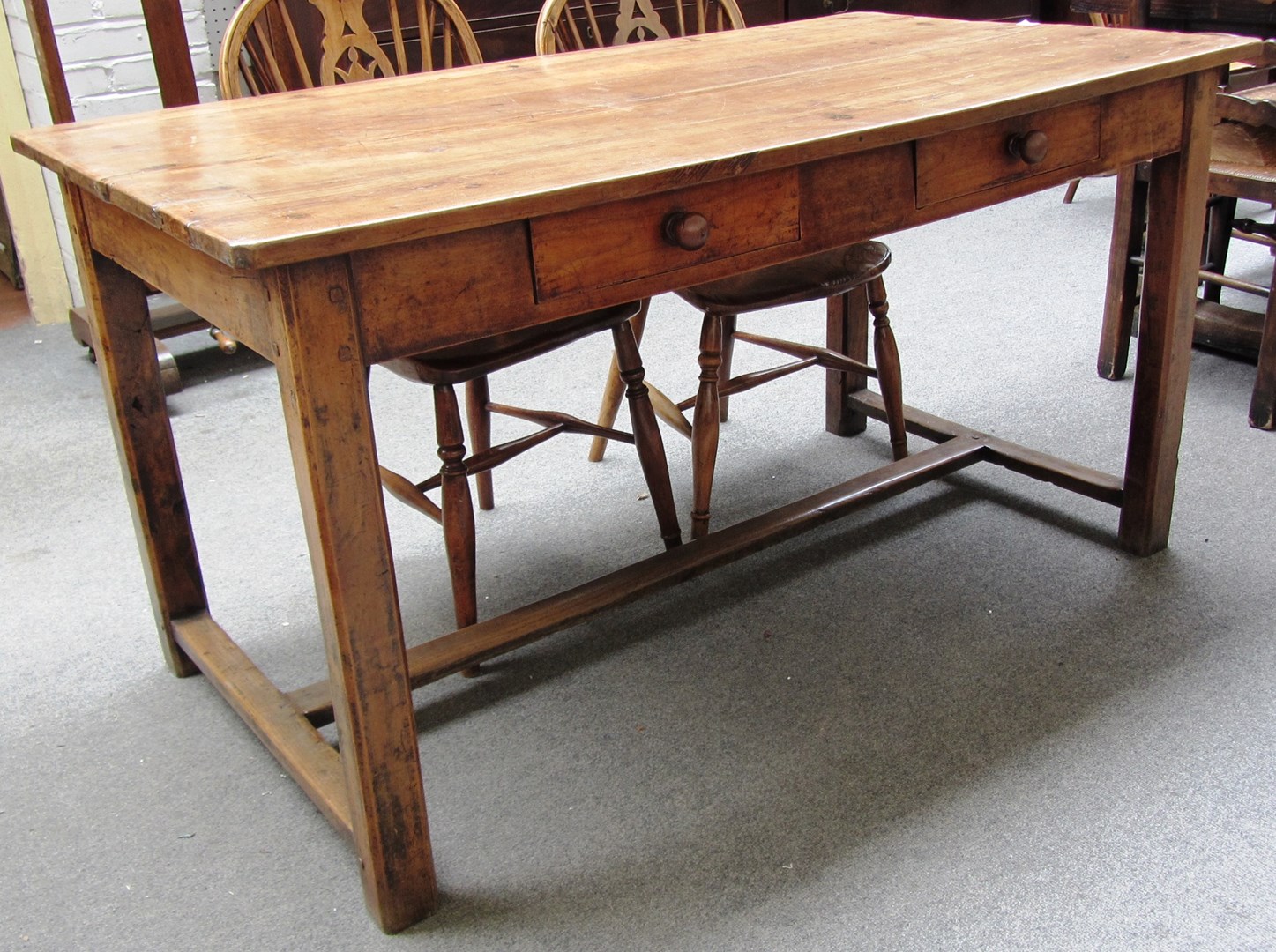 Appraisal: An th century French fruitwood plank top kitchen table on