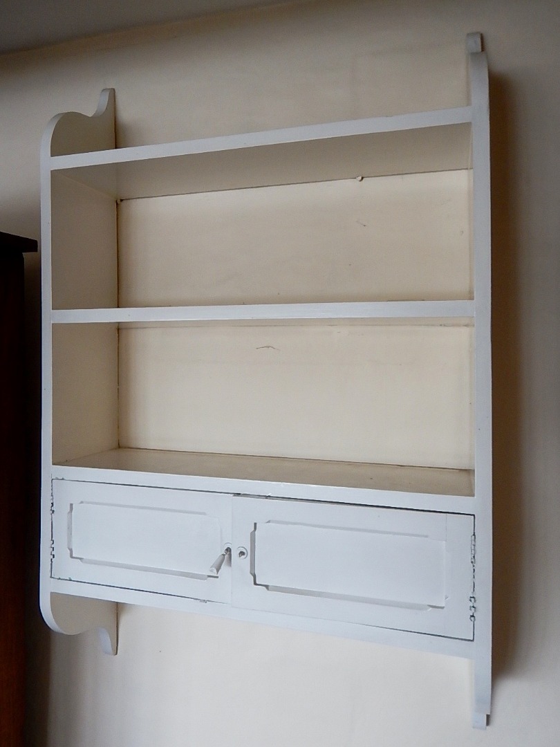 Appraisal: A white painted hanging bookrack with two shelves and a