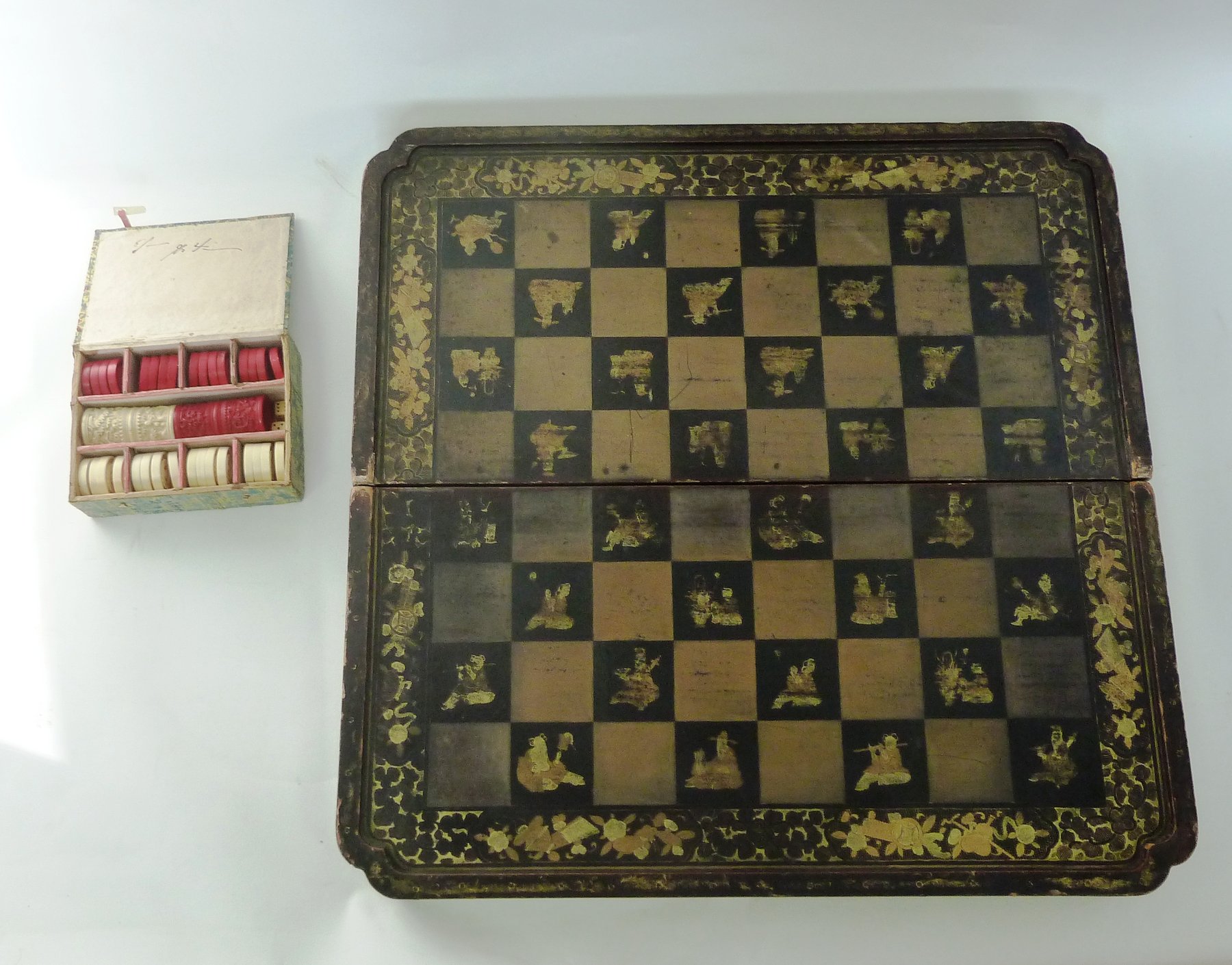 Appraisal: A Chinese folding backgammon draughts board with lacquered decoration throughout