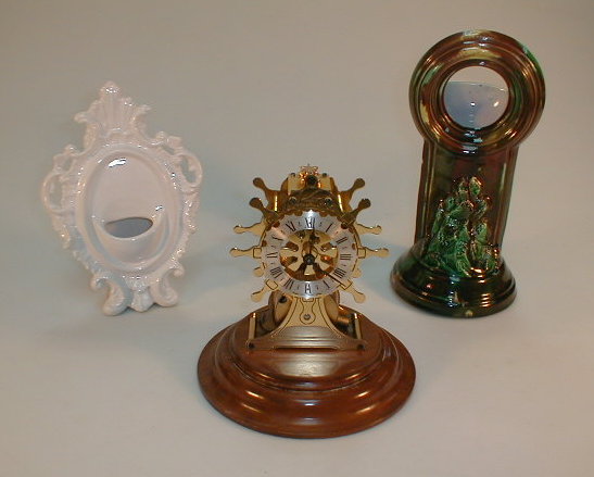 Appraisal: A reproduction skeleton clock and two pottery pocket watch stands