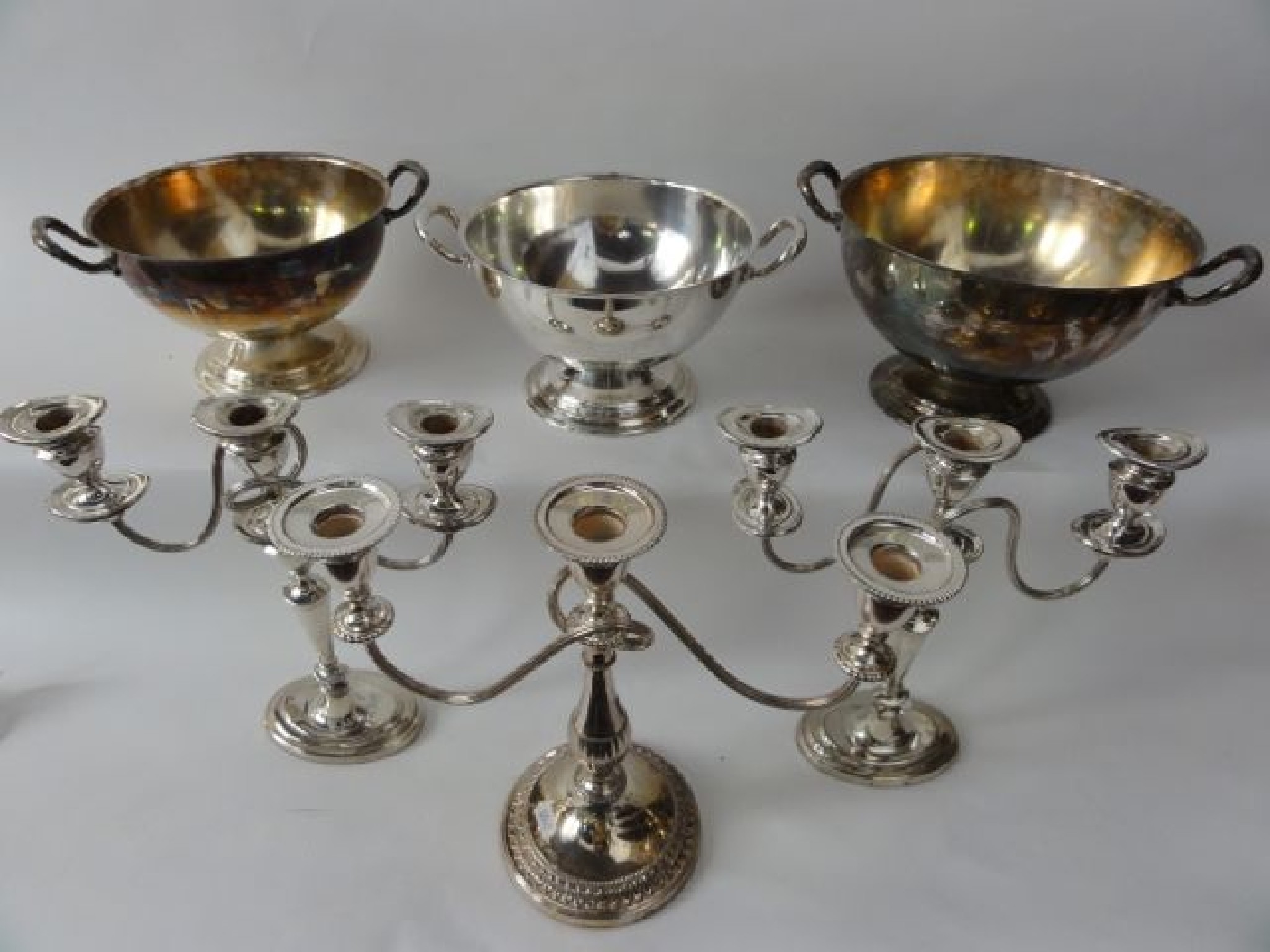 Appraisal: A pair of silver plated two branch candelabra raised on