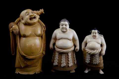 Appraisal: THREE JAPANESE IVORY OKIMONO including a patinated ivory figure of