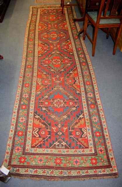 Appraisal: A PERSIAN RUNNER the central rectangular field filled with four