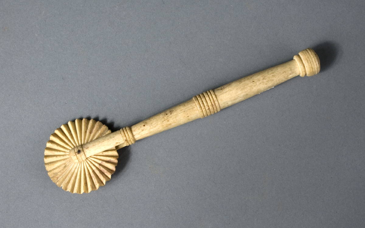 Appraisal: CARVED WHALEBONE JAGGING WHEEL With cylindrical turned handle Length inches