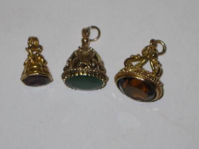 Appraisal: THREE VARIOUS HARDSTONE WATCH FOBS set in pierced gold mounts