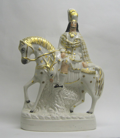 Appraisal: STAFFORDSHIRE POTTERY FIGURE GROUP Depicting hunter on horseback carrying stag