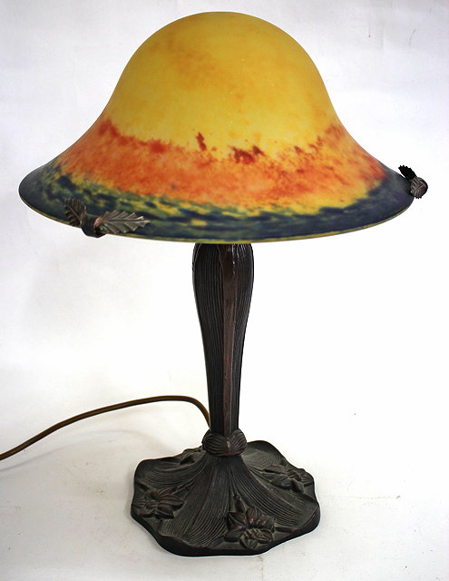 Appraisal: A DECORATIVE ART NOUVEAU STYLE BRONZED TABLE LAMP with glass