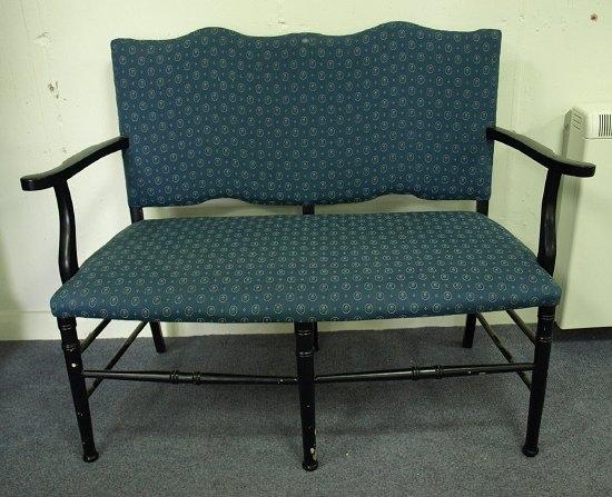 Appraisal: A two-chair back settee with twin arch back on ebonised