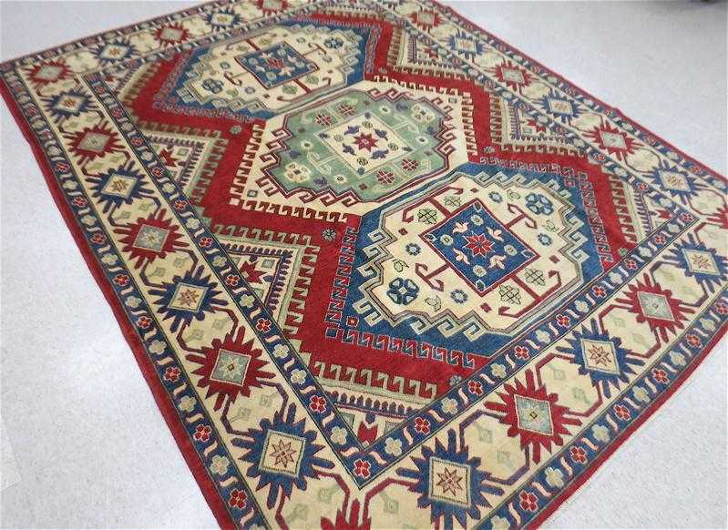 Appraisal: HAND KNOTTED ORIENTAL CARPET Pakistani-Caucasian Kazak three geometric medallion design