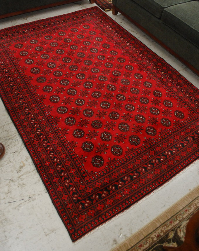 Appraisal: AFGHANI TURKOMAN AREA RUG the red field decorated with repeating