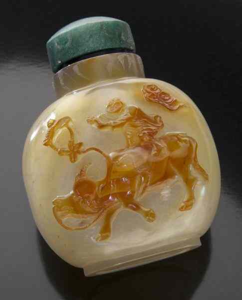 Appraisal: Chinese Qing carved agate snuff bottledepicting a man riding a