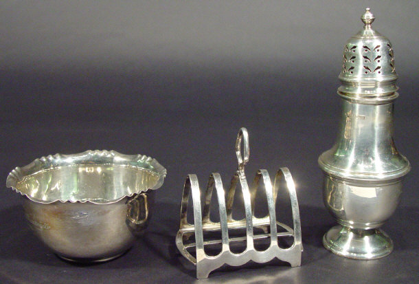 Appraisal: Silver circular based sugar sifter silver four slice toast rack