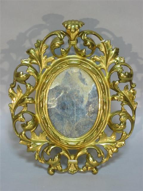 Appraisal: BAROQUE STYLE BRASS MIRROR ON STAND Gilt-metal oval mirror the