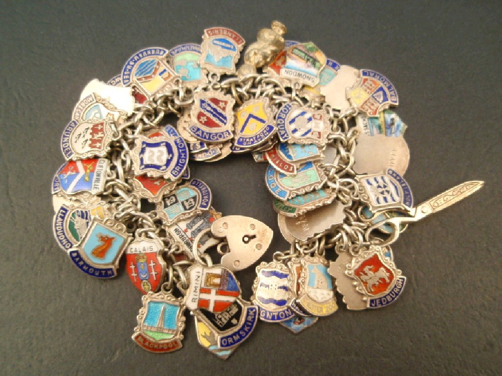 Appraisal: A silver charm bracelet with attached enamelled town and county