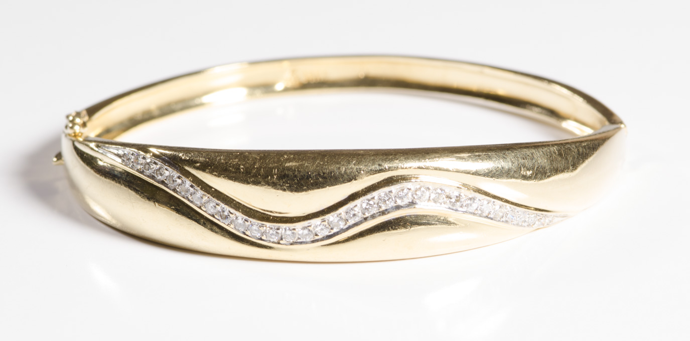 Appraisal: DIAMOND AND FOURTEEN KARAT GOLD BANGLE the wider portion featuring