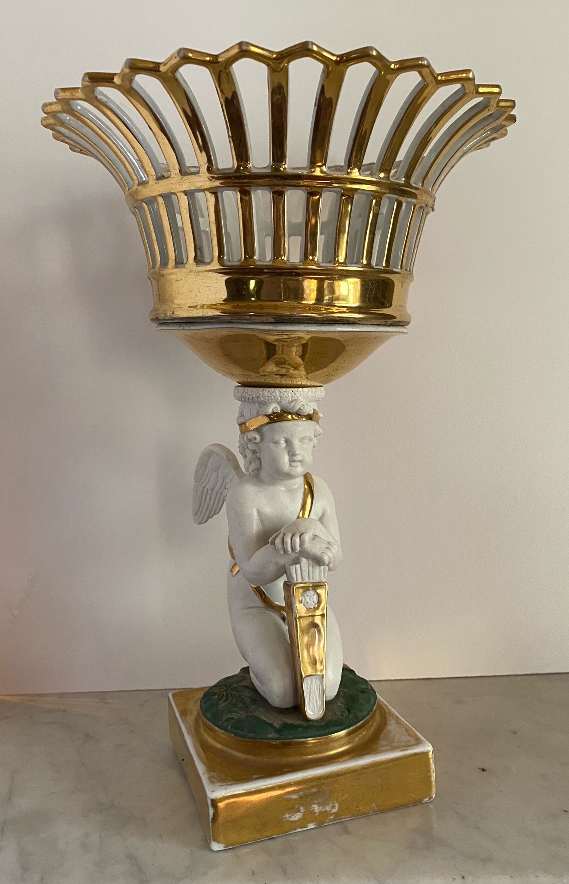 Appraisal: European porcelain white and gilded compote- Cupid supporting a reticulated