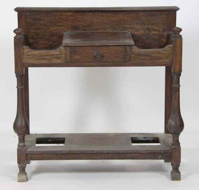 Appraisal: An oak umbrella stand fitted a central glove drawer on