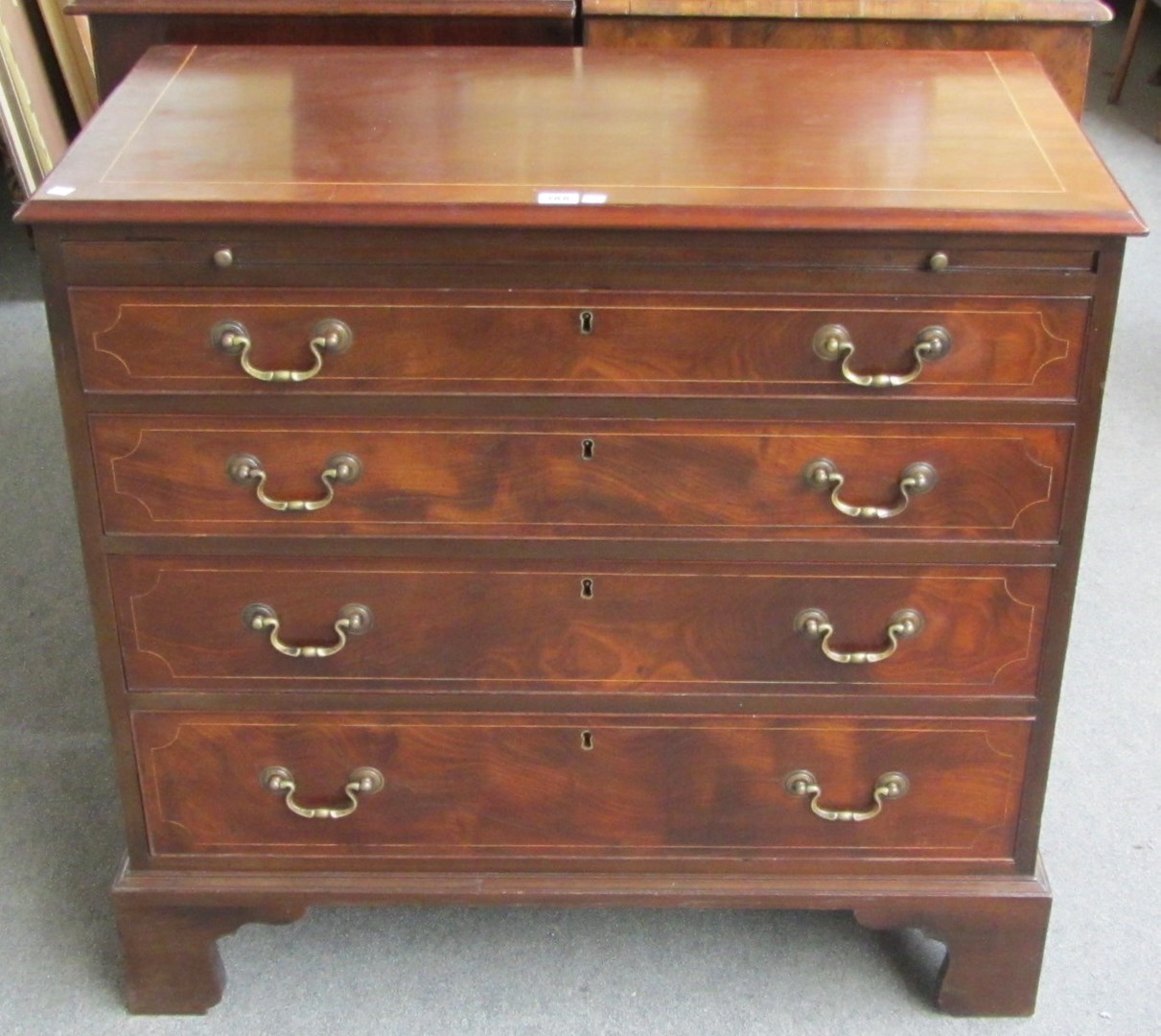 Appraisal: A George III inlaid mahogany chest the brushing slide over