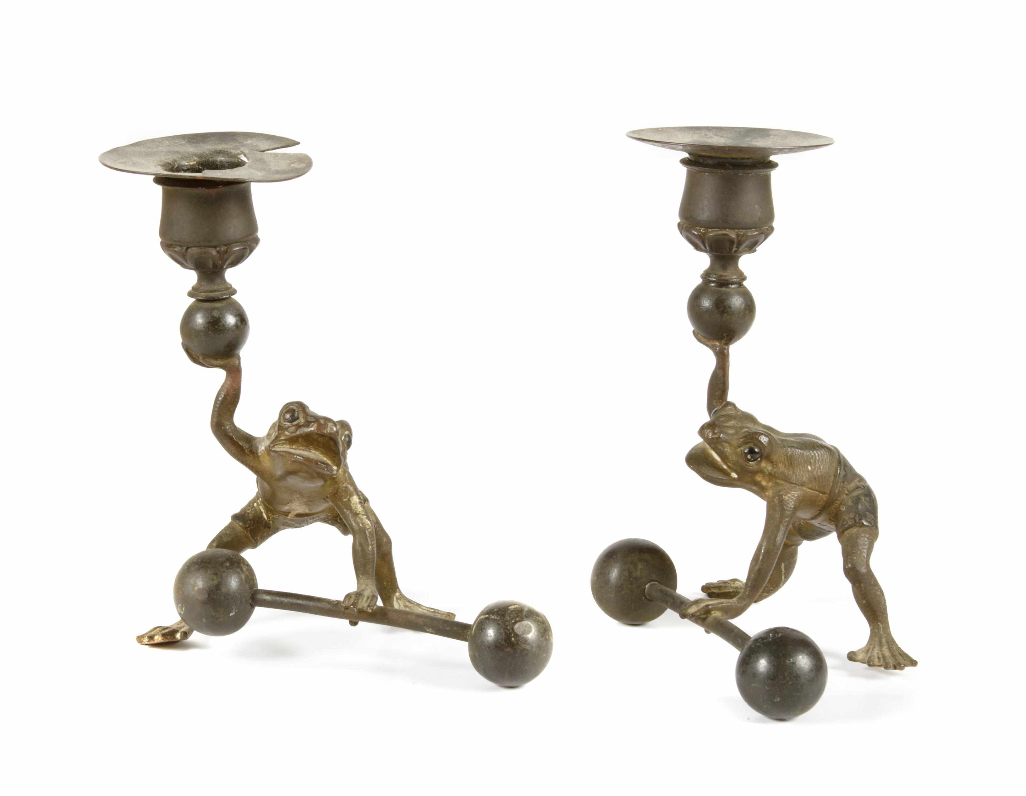 Appraisal: A pair of whimsical patinated metal candelsticks Modeled as athletic