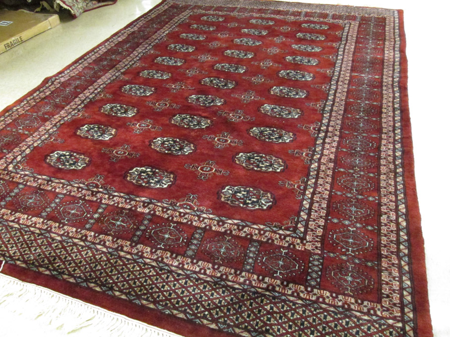 Appraisal: RED FIELD BOKHARA CARPET India or Pakistan hand knotted '