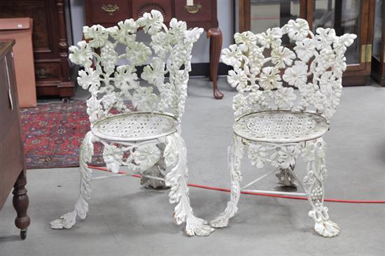 Appraisal: TWO CAST IRON GARDEN CHAIRS White painted chairs with foliate