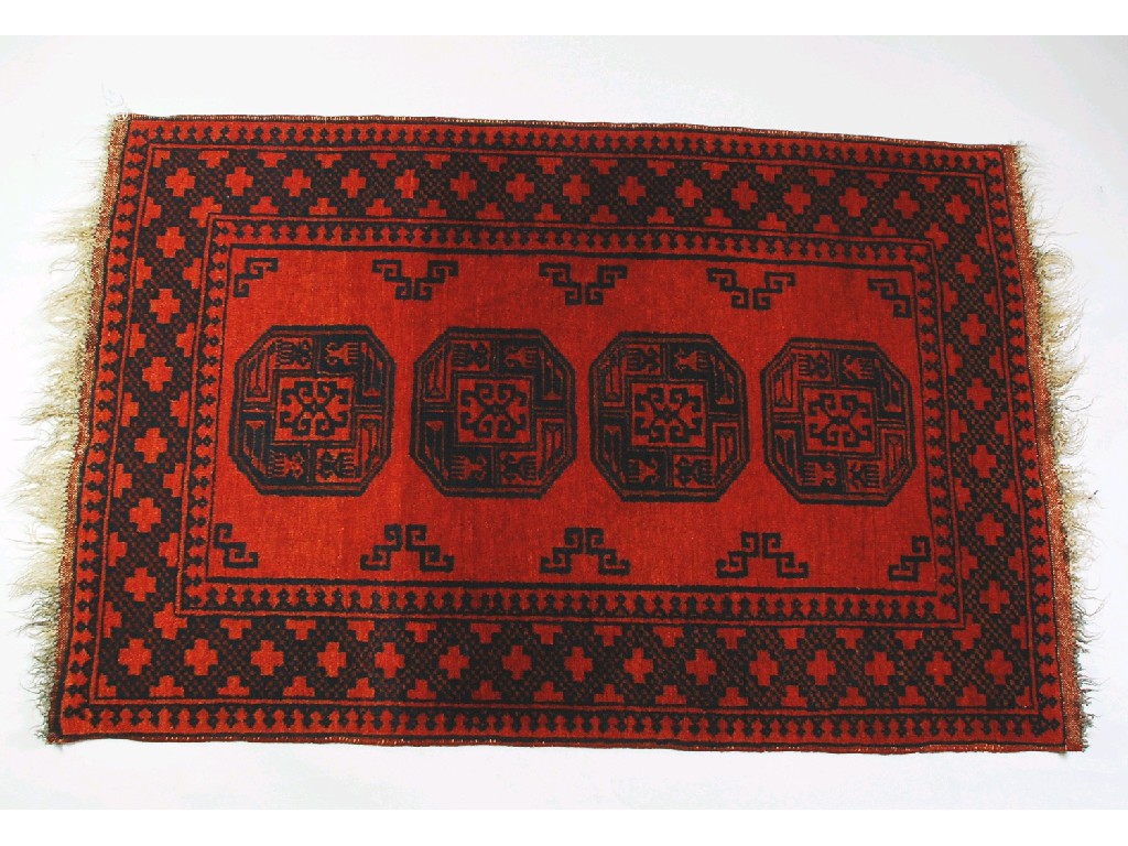 Appraisal: AFGHAN HAND MADE ALL WOOL RUG crimson with a row