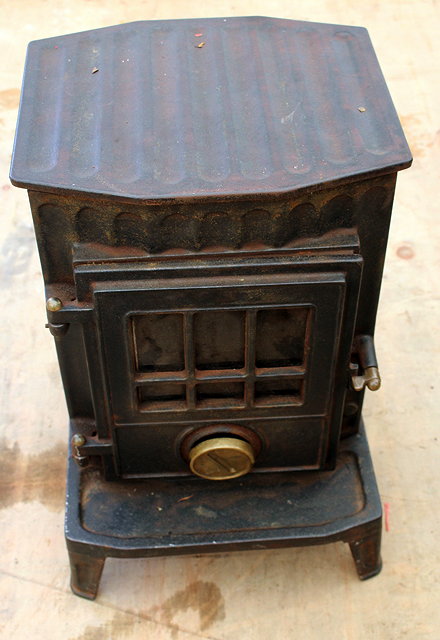 Appraisal: A CAST IRON WOOD BURNING STOVE approximately cm wide